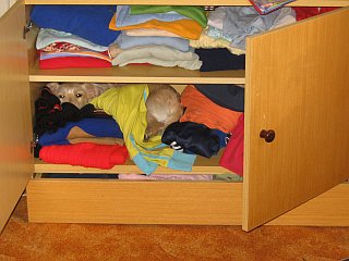 Zlatka nasáčkovaná mezi oblečením v paniččině skříňce